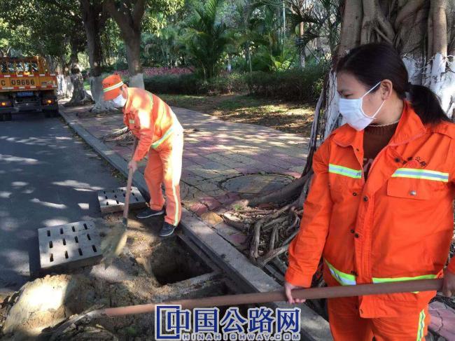 陈德清夫妇在清理公路下水道积土.jpg
