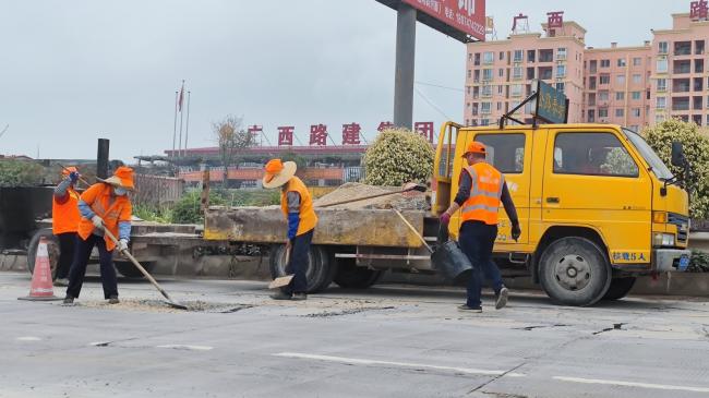 藤县养护工人对G321线出现的路面裂缝进行修补（罗凯惠 摄）.jpg