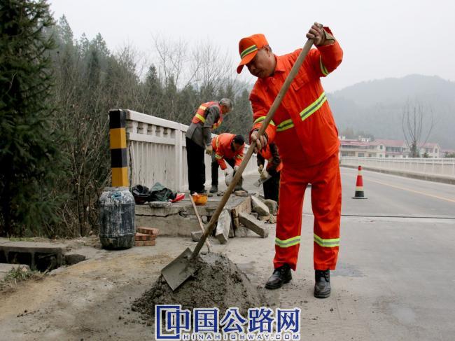 吴新沙与同事一起修复桥栏。.jpg