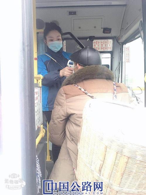 2020年3月4日，杨显凤为乘客测量体温与整理佩戴不规范的口罩图。蒋文友 摄影.jpg